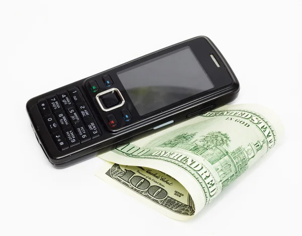 Mobilní telefon a bankovky dolaru — Stock fotografie