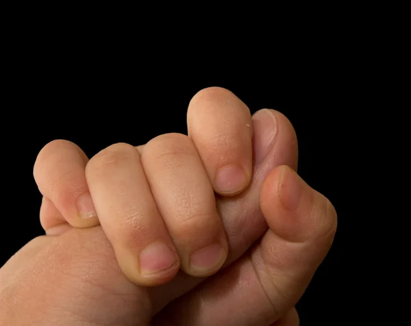 The hand of the child holds a finger of the father on a black ba — Stock Photo, Image