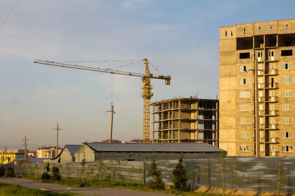 Casas no terminadas y grúa torre en Kazajstán. Shymkent. — Foto de Stock