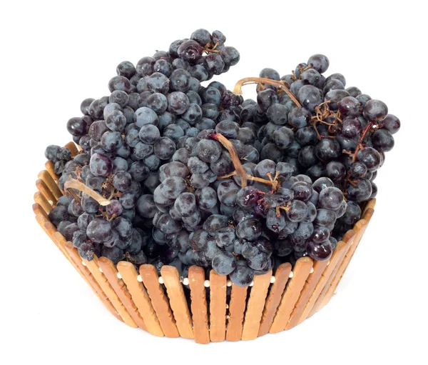 Черный виноград в корзине на белом фоне — стоковое фото