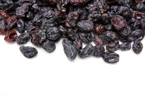 Beyaz zemin üzerine siyah kuru üzüm — Stok fotoğraf