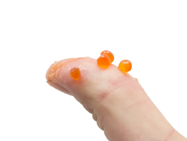 Prst v červený kaviár na bílém pozadí — Stock fotografie