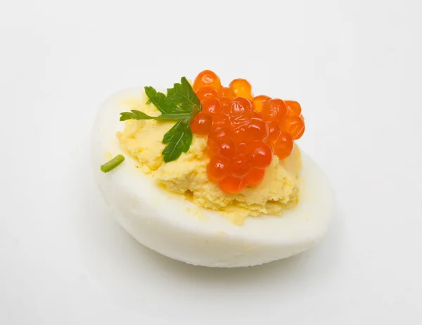 Ovo com caviar vermelho e salsa sobre um fundo branco — Fotografia de Stock