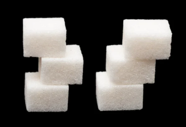 Three lumps of sugar on a black background Stock Picture