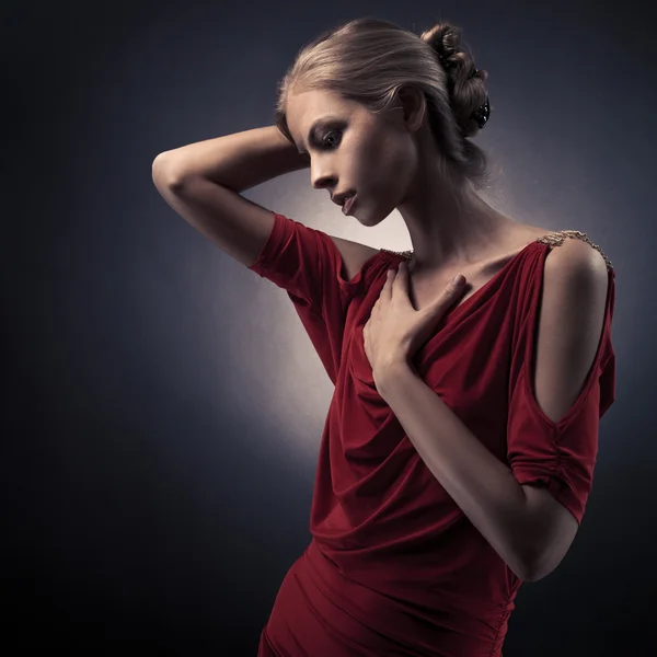 Jovem mulher bonita em vestido vermelho no fundo escuro no — Fotografia de Stock