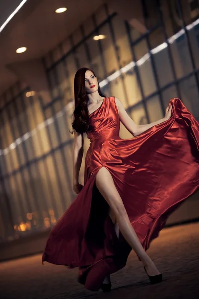 Sexy mladá kráska žena v vlající červené šaty — Stock fotografie