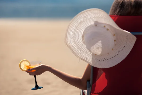 Woman holding a fruit cocktail on a tropical beach — Stock Photo, Image