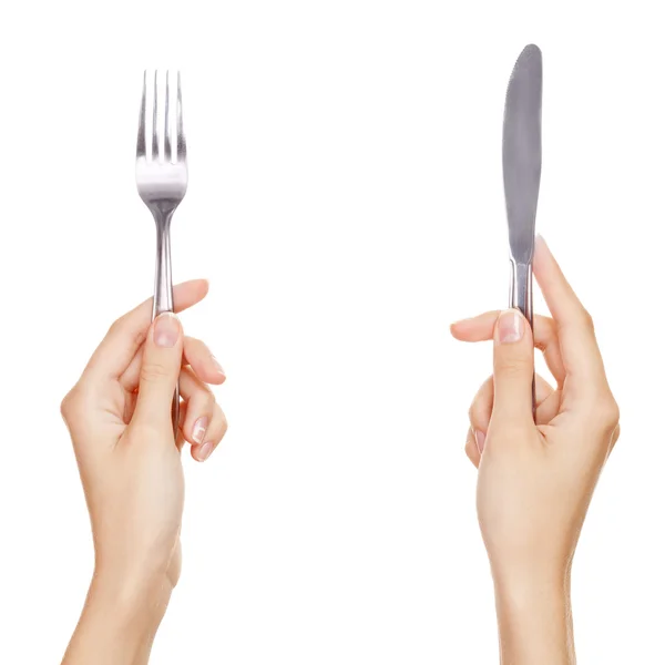 刀和叉正在举行的由女人的手。在白色隔离. — 图库照片