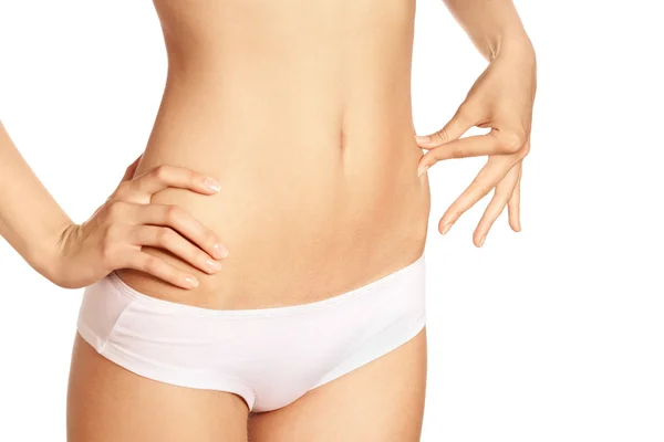 Schlank gebräunter Frauenkörper isoliert vor weißem Hintergrund. Gesund — Stockfoto