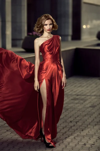 Sexy young beauty woman in fluttering red dress — Stock Photo, Image
