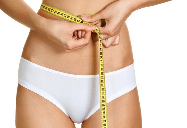 Portrait of young conscious woman measuring her waist over white — Stock Photo, Image
