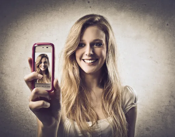 Νεαρή γυναίκα λαμβάνοντας φωτογραφίες με ένα κινητό τηλέφωνο — Φωτογραφία Αρχείου