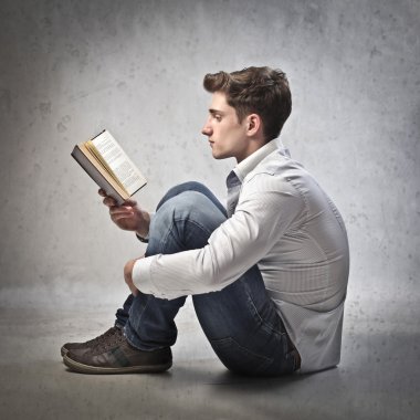 Young man reading a book clipart