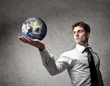 Young businessman holding the Earth in his hand [Elements of this image furnished by NASA]