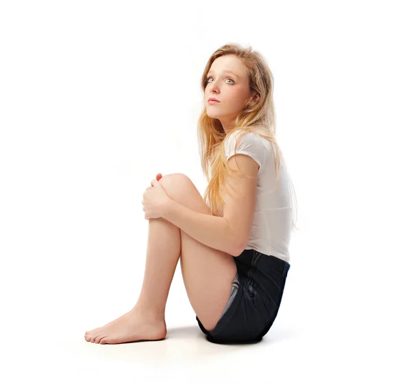 Geïsoleerde zittende jonge vrouw — Stockfoto