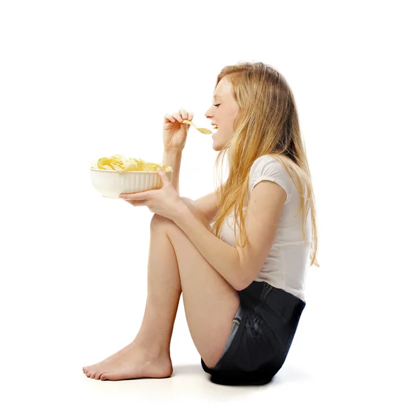 Na białym tle siedzący młodej kobiety jedzenie kilka frytek — Zdjęcie stockowe