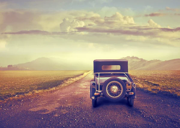 Винтажный автомобиль на пустынной дороге . — стоковое фото