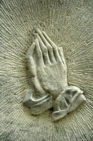 Prier les mains sur une pierre tombale — Photo