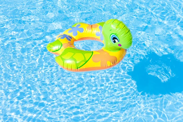 Child's green rubber ring in swimming pool — Stock Photo, Image