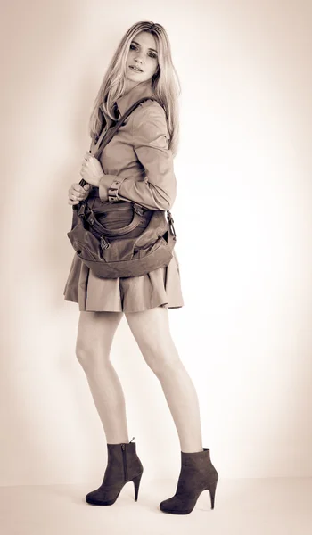 Mulher de pé vestindo casaco e sapatos na moda com uma bolsa — Fotografia de Stock