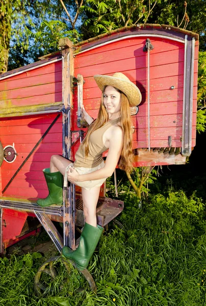 Young woman standing by old threshing machine — Stock Photo, Image
