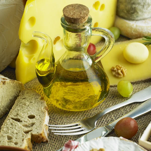 Cheese still life with olive oil — Stock Photo, Image