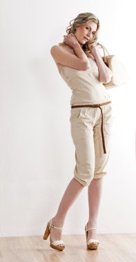 Yazlık giysiler ve ayakkabı giyen duran kadın