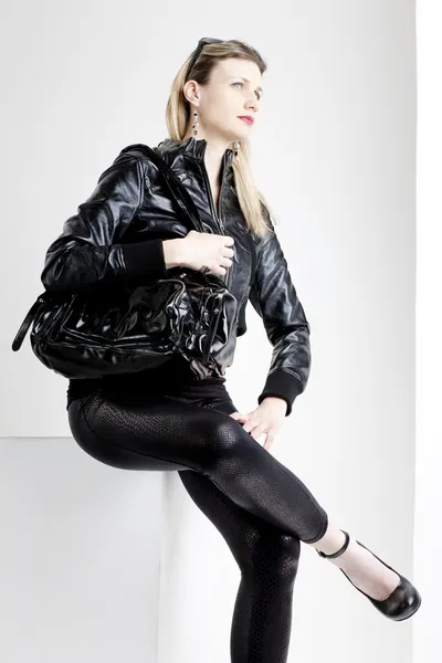 Сидящая женщина в модной черной одежде — стоковое фото
