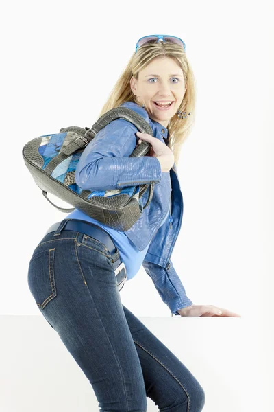 Стоячая женщина в синей одежде с сумочкой — стоковое фото