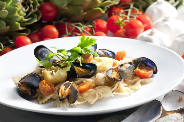 Pasta med musslor, kronärtskockor och körsbärstomater — Stockfoto