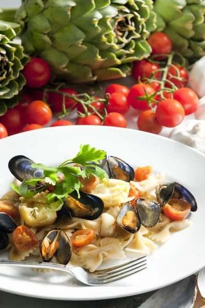 Pasta with mussels, artichokes and cherry tomatoes — Zdjęcie stockowe