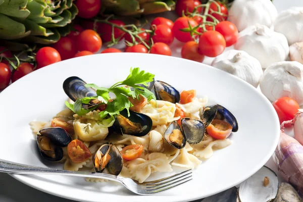 Pasta med musslor, kronärtskockor och körsbärstomater — Stockfoto