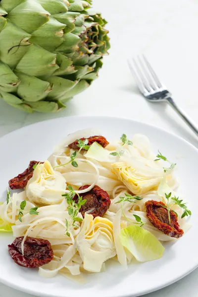 Pasta with dried tomatoes and artichokes — Stock Photo, Image