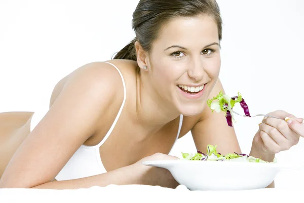 横たわっているサラダを食べる女の肖像 — ストック写真