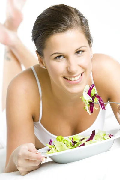 Ritratto di donna sdraiata che mangia insalata — Foto Stock