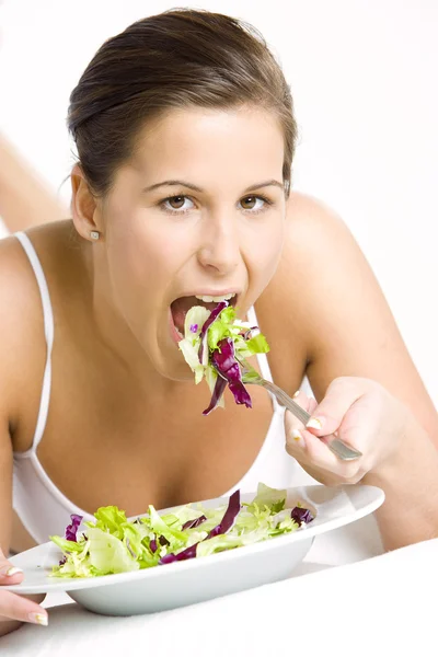 Портрет лежащей женщины, поедающей салат — стоковое фото
