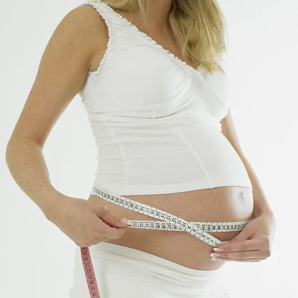 Mulher grávida com fita métrica — Fotografia de Stock