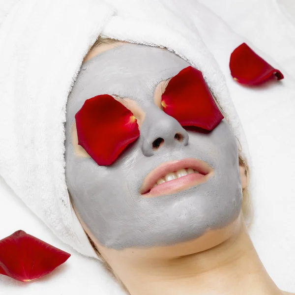 Kvinna med ansiktsmask och rose — Stockfoto