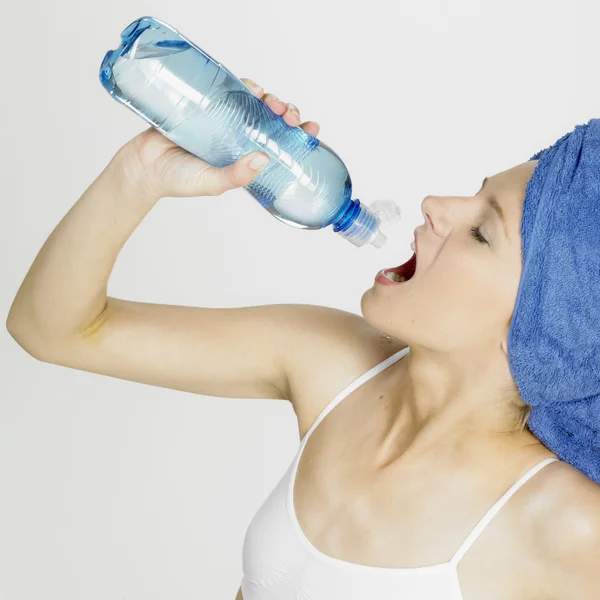 Vrouw met handdoek op hoofd drinkwater — Stockfoto