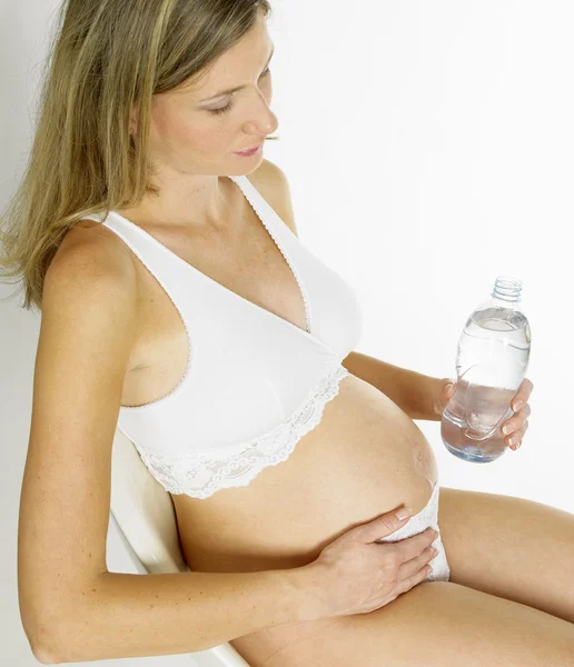 Беременная женщина с бутылкой воды — стоковое фото