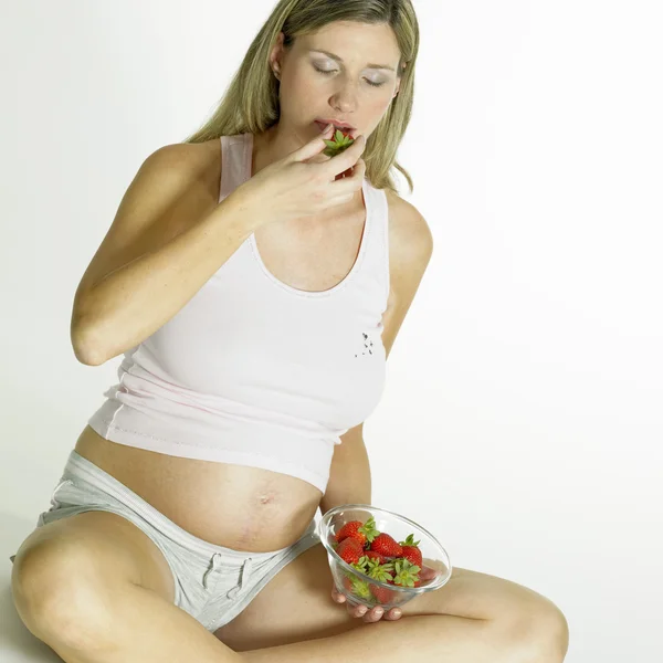 Беременная женщина с клубникой — стоковое фото