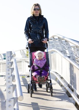 Woman with toddler sitting in pram on walk