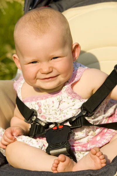 Малышка сидит в коляске — стоковое фото