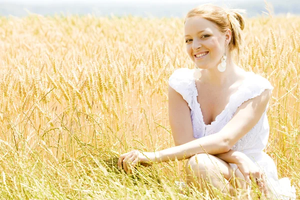 Retrato de la mujer sentada en el campo de grano — Foto de Stock