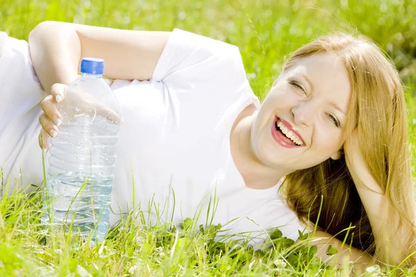 Vrouw met fles water liggen — Stockfoto