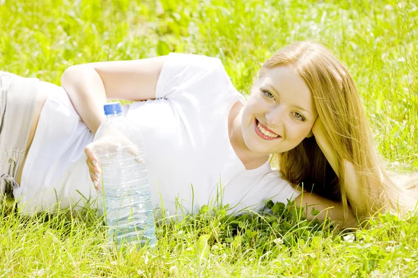 Lying woman with bottle of water — Stock Photo, Image