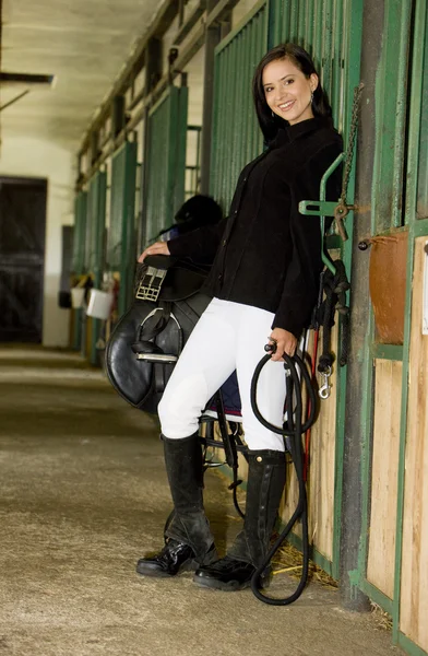 Equestrian with saddle in a stable — Stock Photo, Image