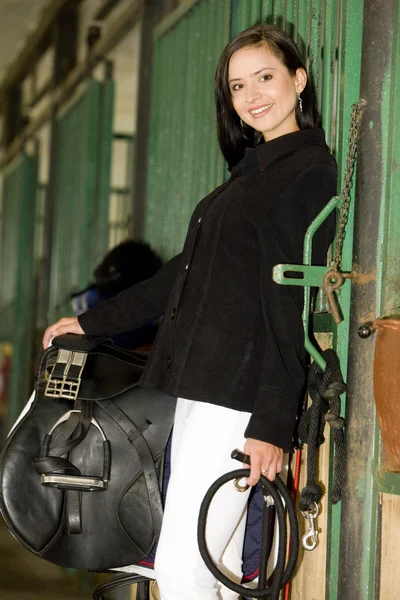 Equestrian with saddle in a stable — Stock Photo, Image