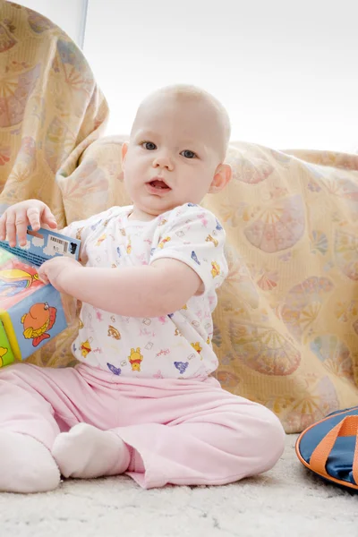 Baby girl with toys sitting on the carpet — Stock Photo, Image