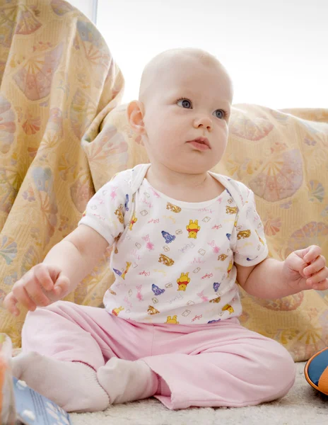 Baby flicka sitter på mattan — Stockfoto
